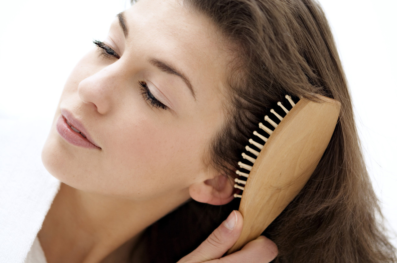 Portrait of a young woman brushing her hair